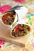 Burritos with minced meat, tomatoes, red onions and guacamole