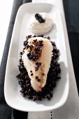 A fillet of fish with liquorice on black rice