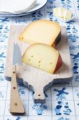 Dutch cheeses (Leerdammer, Old Amsterdam) on a board on a Dutch tablecloth