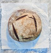 Brot auf Papier und Marmorplatte mit Mehl