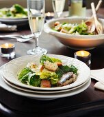 Caesar Salad mit Sardinen auf festlich gedecktem Tisch