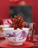 A bundle of chilli peppers in a porcelain bowl with a dragon motif