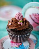 A chocolate cupcake with a decorative heart