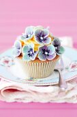 A cupcake decorated with blue flowers