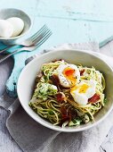 Spaghetti with chicken and ham; a soft-boiled egg on top
