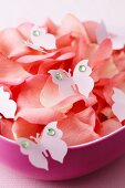 Flower petals and decorative butterflies in a bowl