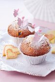Muffins with icing sugar and decorative butterflies on spikes