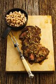 Beef steak with chillies, shallots and white beans