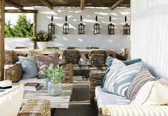 Rattan sofa set with seat cushions and scatter cushions under terrace pergola of holiday home