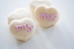 Heart-shaped macaroons decorated with writing using sugar icing