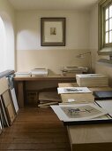 Black and white photographs on two tables in gallery study of historic country house