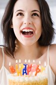 Woman laughing next to birthday cake