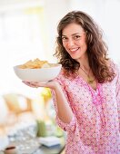 Woman carrying bowl with snacks