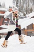 Junge Frau läuft durch den Schnee im Skigebiet