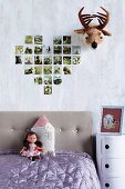 Collection of family photographs arranged in heart on wall next to amusing fake plush animal head