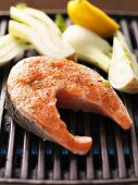 Raw spiced salmon steak and fennel on the barbecue