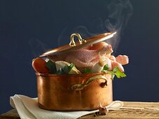 Stewing chicken with vegetables in a copper pot