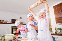 Germany, Girls and boy baking cup cakes in kitchen