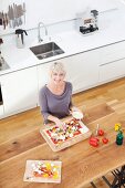 Germany, Bavaria, Munich, Woman preparing pizza in kitchen