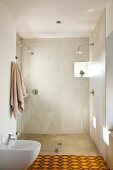 Simple shower room with two shower heads, glass partition and tiny window; yellow and brown carpet in foreground