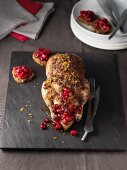A small, stuffed duck with cranberries and oranges