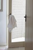 Anteroom with open, white doors; towel hanging on nostalgic door handle