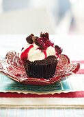 A Black Forest cherry cupcake with cherry compote and white chocolate cream topping