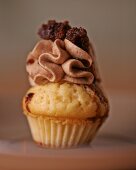 A cupcake topped with chocolate cream