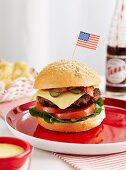 Klassischer Hamburger mit Bacon; dazu frittierte Zwiebelringe