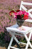 Summer bouquet of dahlias and heather on garden chair
