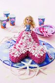 A child's birthday cake with a mermaid doll