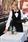 A waitress laying the table in a restaurant