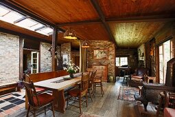 Dining area in rustic open-plan interior of simple country house