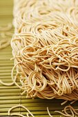 Chinese egg noodles on a bamboo mat (close-up)