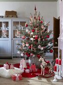 Decorated Christmas tree and presents on floor in rustic living room