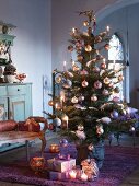 Decorated Christmas tree with presents on floor in interior of country house villa