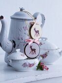 Old floral coffee pot and sugar bowl on white painted wooden surface