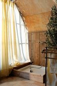 Rustikale Duschecke neben Fenster mit luftigem Vorhang in Zimmerecke unter Tonnendecke