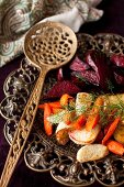Roasted Root Vegetables with Fennel Fronds on a Platter with a Spoon
