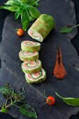 Spinach and Basil Smoked Salmon Roll; Sliced with Sauce on a Piece of Slate