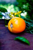 Whole Yellow Tomato with a Basil Leaf