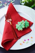 Clover leaf-shaped biscuits and confetti decorating a plate