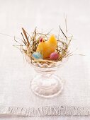 An Easter nest in an egg cup with sweets