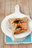 A buckwheat pancake with spinach, tomatoes and egg