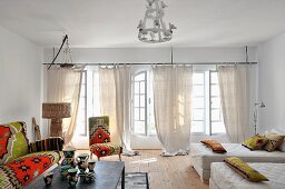 Sofa, chair and scatter cushions with North-African-style covers; patterned chine vases on coffee table