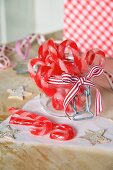 Candy canes in a jar tied with a ribbon for Christmas