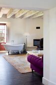 Free-standing vintage bathtub in modern living room with rustic, traditional ambiance