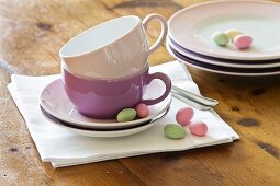 Stacked plates and coffee cups with pastel-coloured sugar eggs