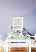 Refurbished old table: glass top with window transfers and printed page hung on lavender wall