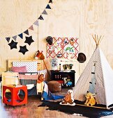 Wooden bed an teepee in a children's room with plywood walls